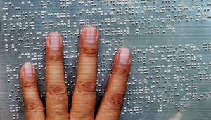 metal braille with hand reading